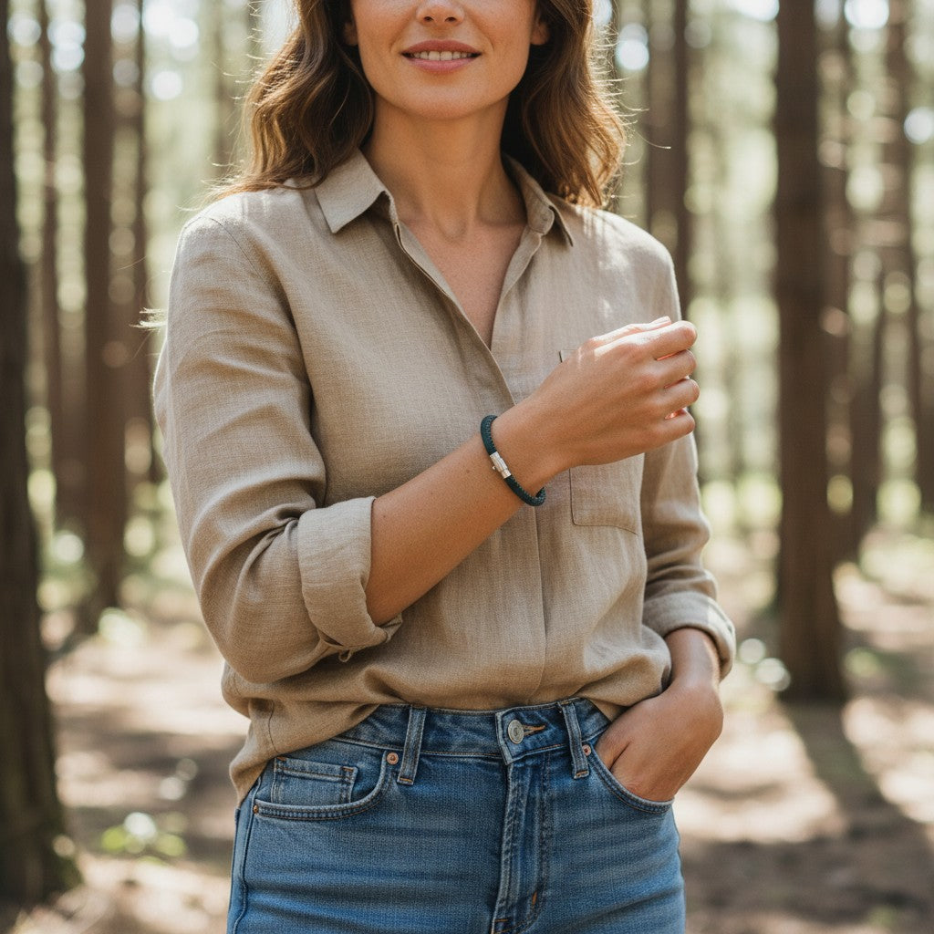 A brunette woman wearing a handcrafted deep teal cork bracelet while standing in a green forest setting, showcasing unisex adult outdoor style by Every Soul Counts.
